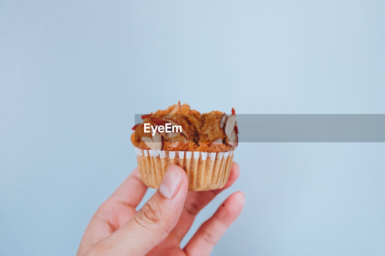 Close-up of hand holding food against white background