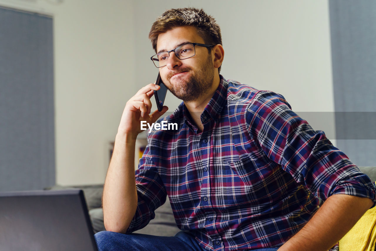 YOUNG MAN USING LAPTOP