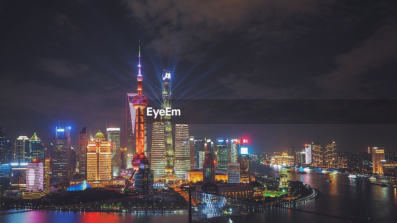 Illuminated buildings in city against sky at night