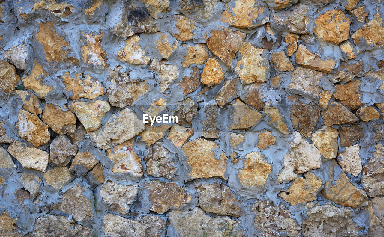 FULL FRAME SHOT OF STONE WALL WITH ROCKS