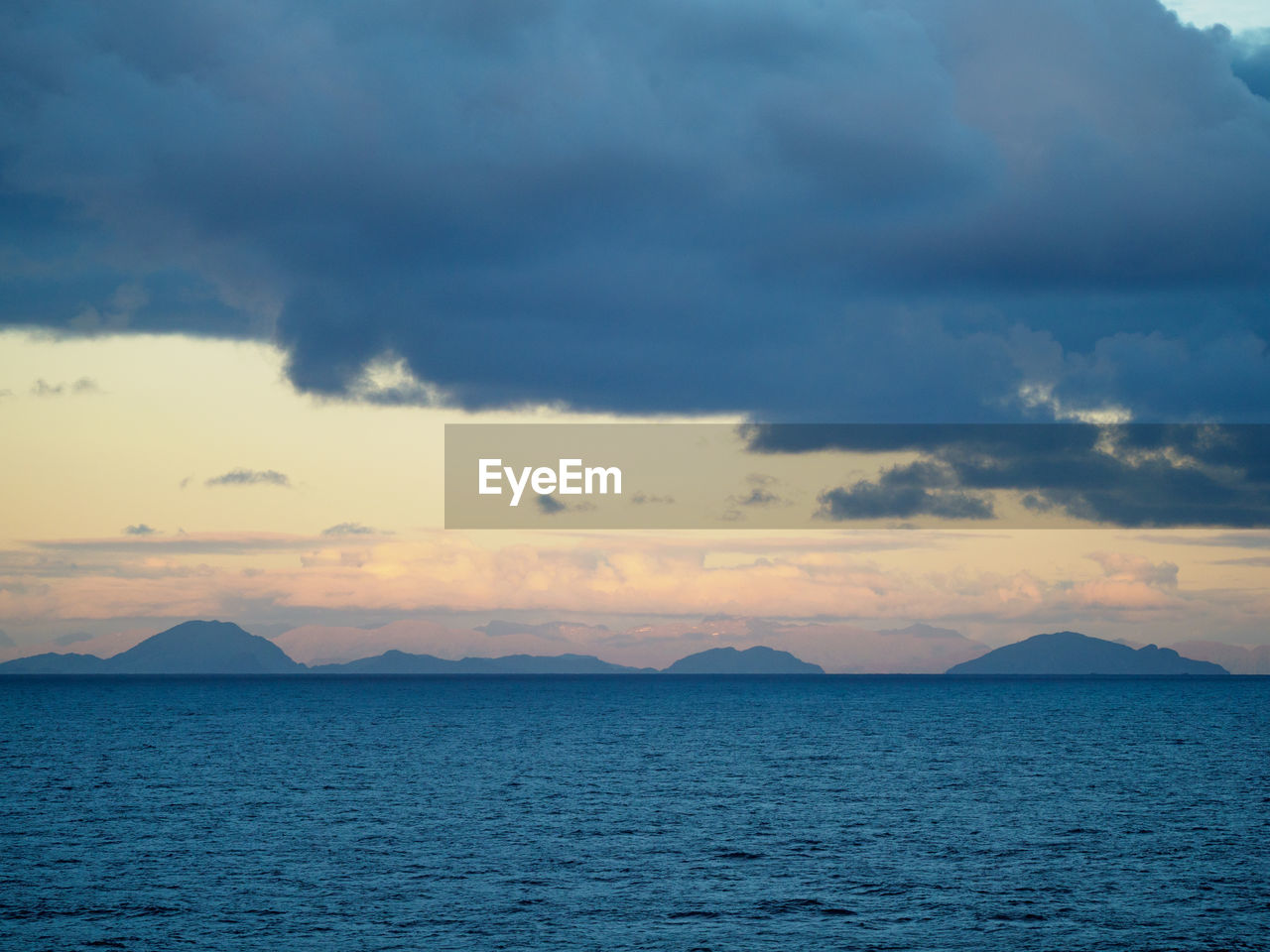 SCENIC VIEW OF SEA BY MOUNTAIN AGAINST SKY