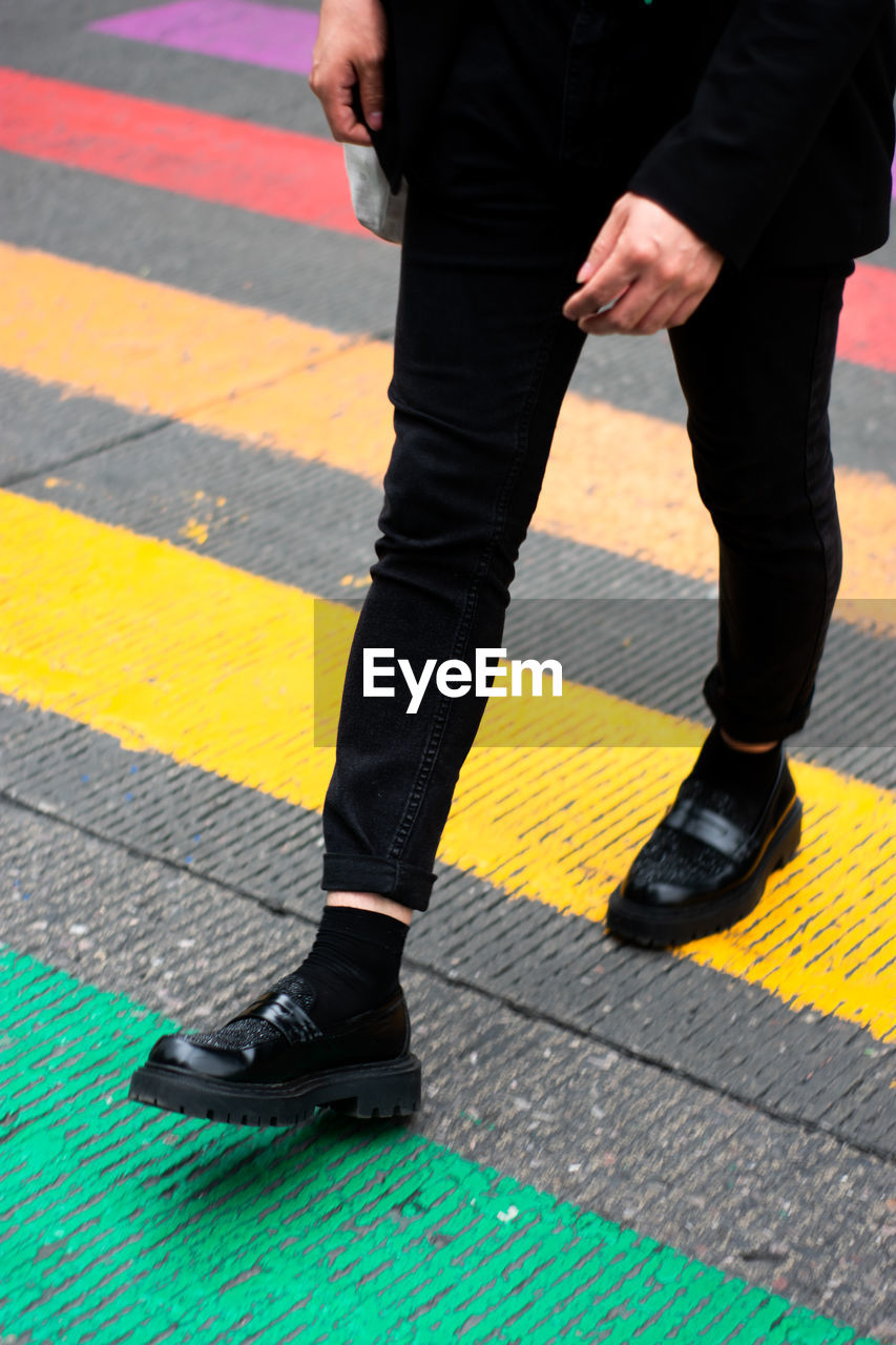 Unrecognizable legs in a crosswalk with the lgbt flag concept