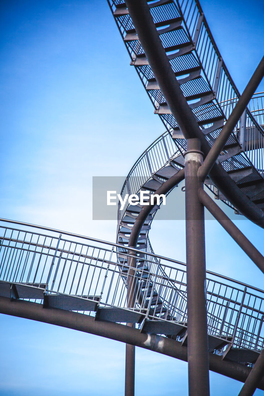 LOW ANGLE VIEW OF METALLIC BRIDGE AGAINST BLUE SKY