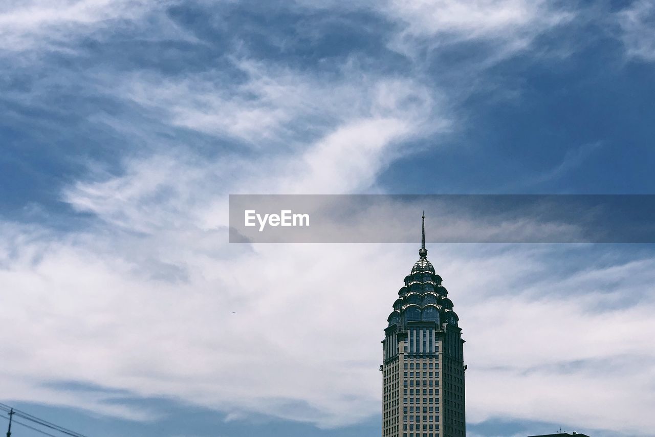 Low angle view of building against cloudy sky