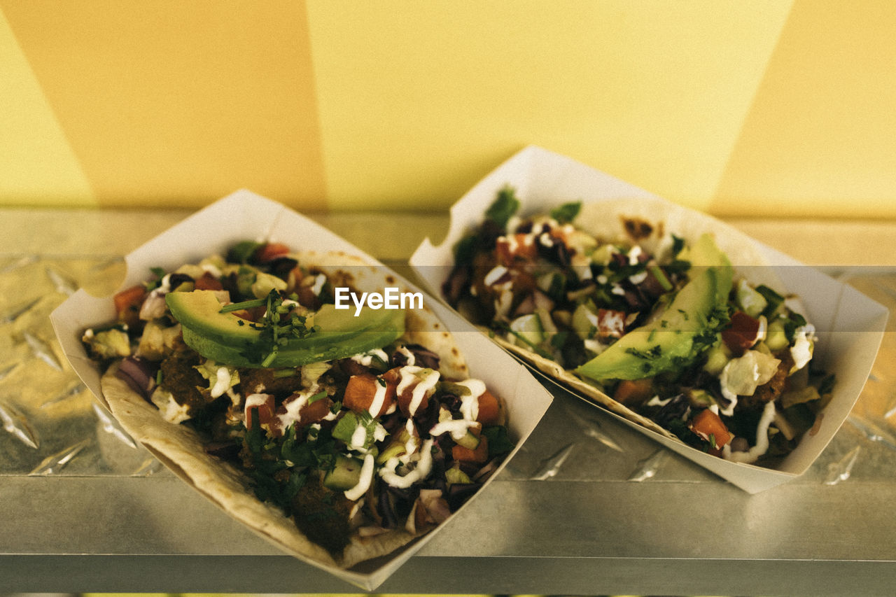 Pair of fresh tacos in take away boxes on concession stand