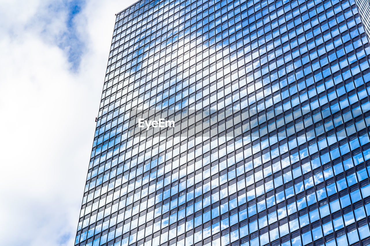 Low angle view of modern building against cloudy sky