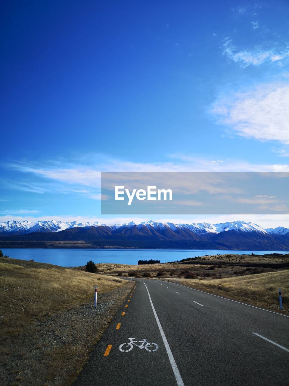 Road leading towards mountains against sky