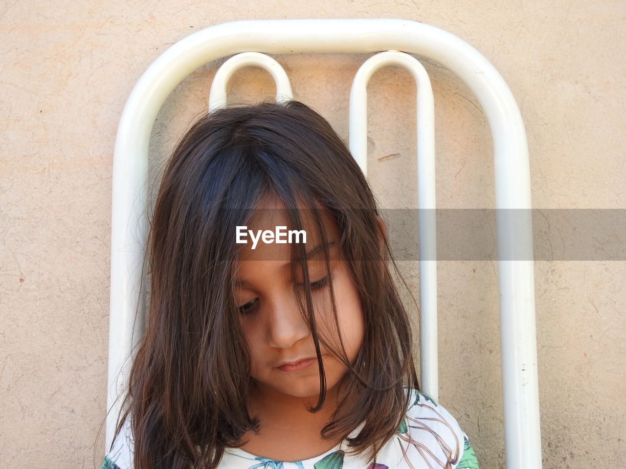 Cute girl looking down against wall