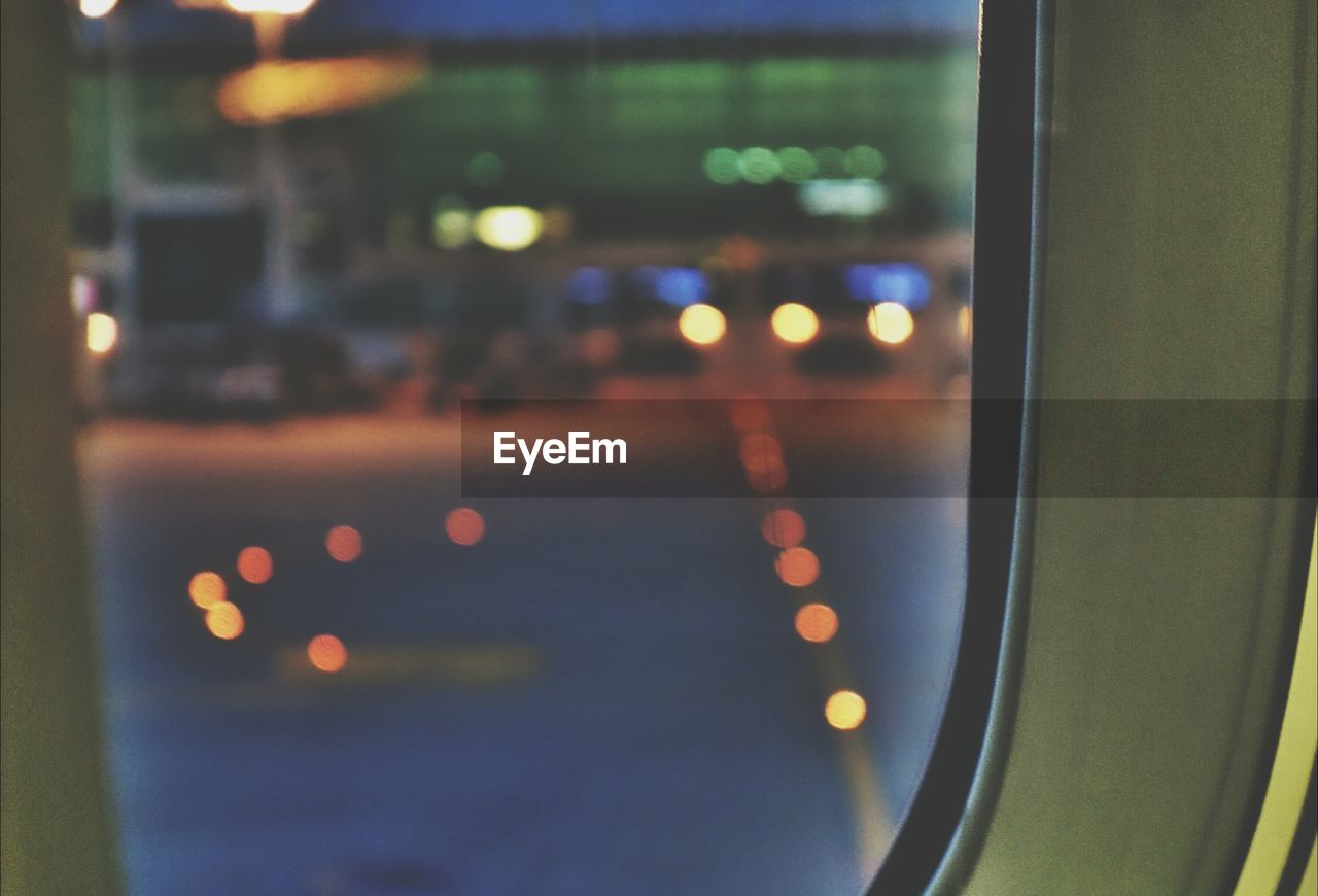 Defocused image of incheon international airport seen through airplane window on runway