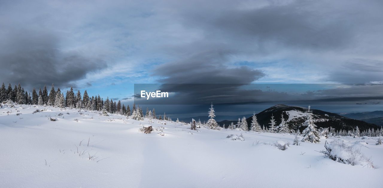 SCENIC VIEW OF SNOW COVERED LAND AND MOUNTAINS AGAINST SKY