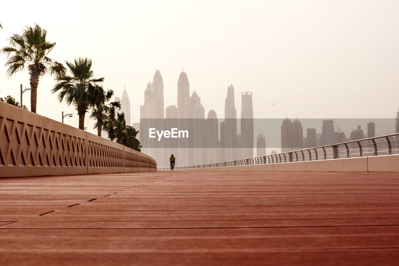 Morning walk, a man riding a bicycle on the road with a beautiful view of dubai. uae