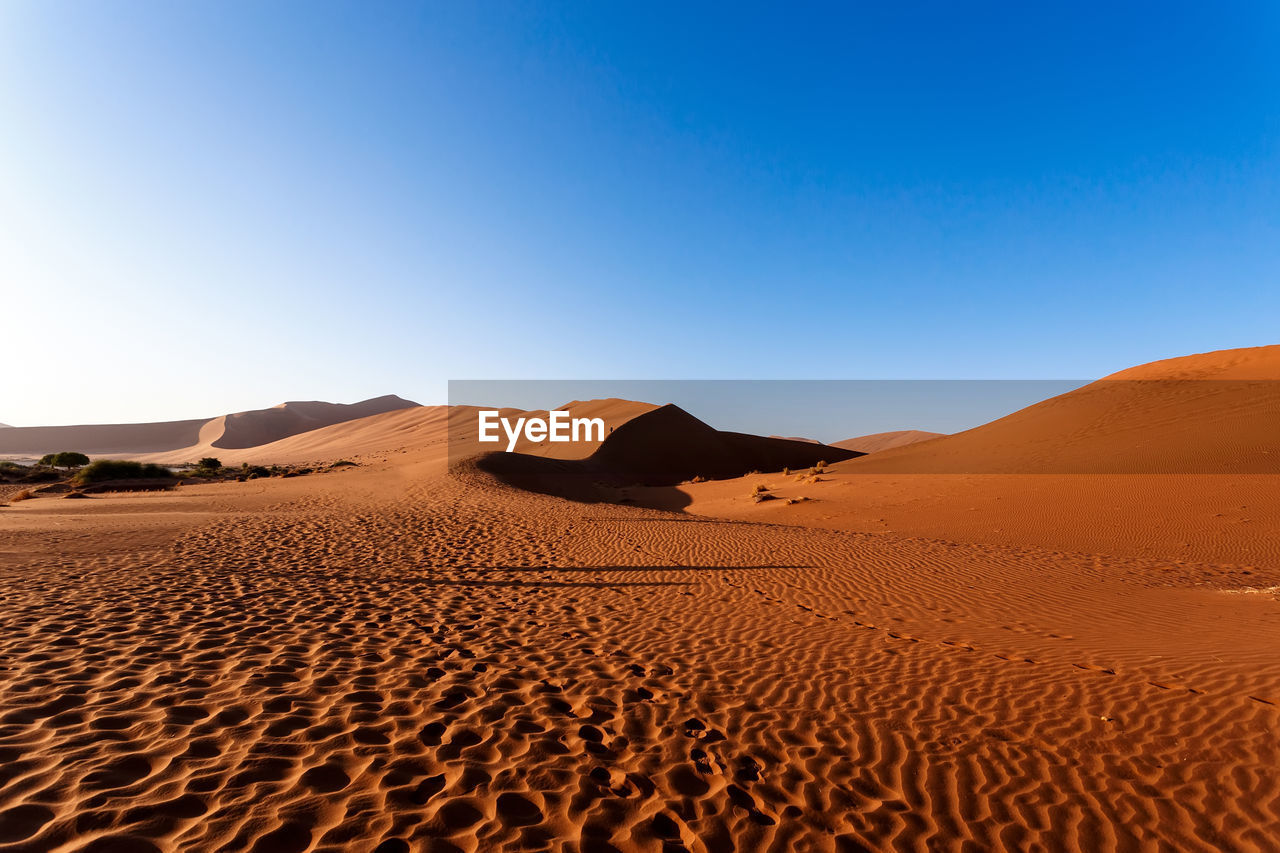 SAND DUNES IN DESERT AGAINST CLEAR SKY