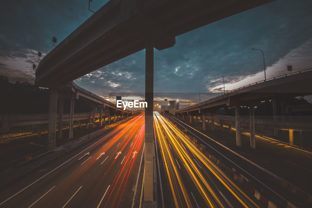 LIGHT TRAILS ON STREET AGAINST SKY IN CITY