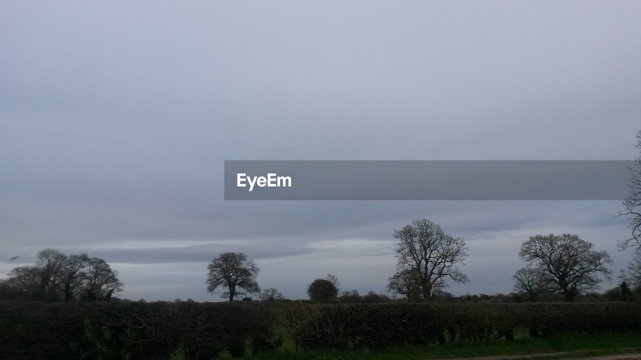 Scenic view of grassy field against cloudy sky