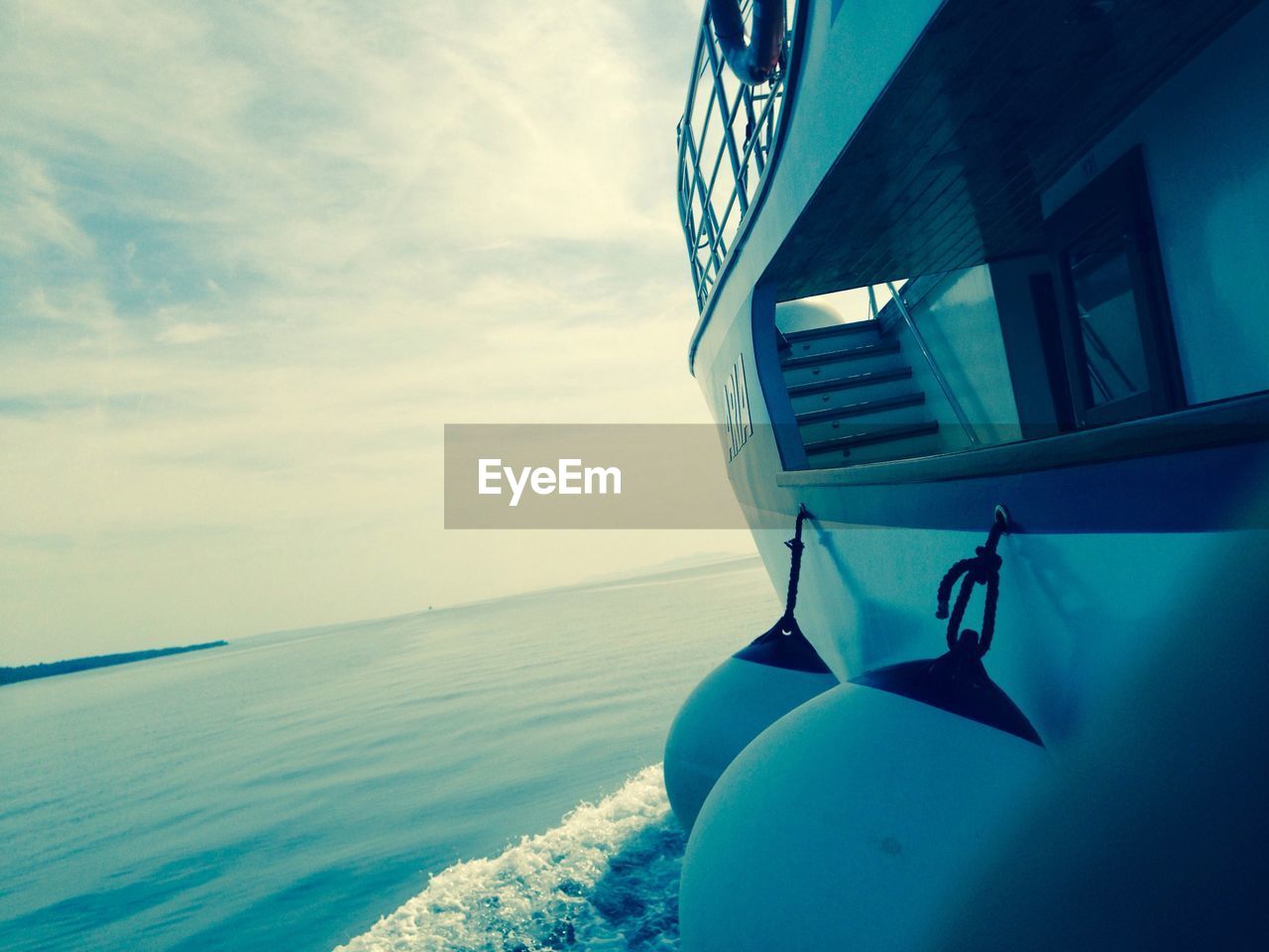 Buoys hanging from ferry in sea against sky