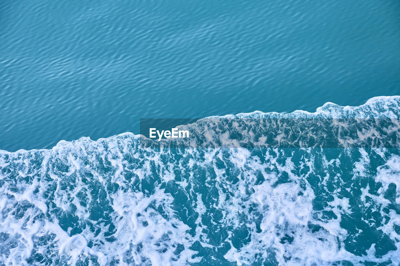 HIGH ANGLE VIEW OF SWIMMING POOL AGAINST SEA