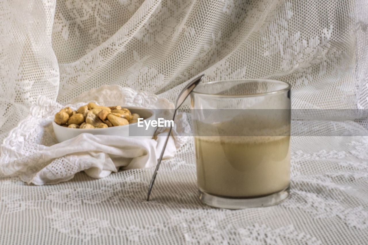 CLOSE-UP OF DRINK WITH FABRIC ON TABLE