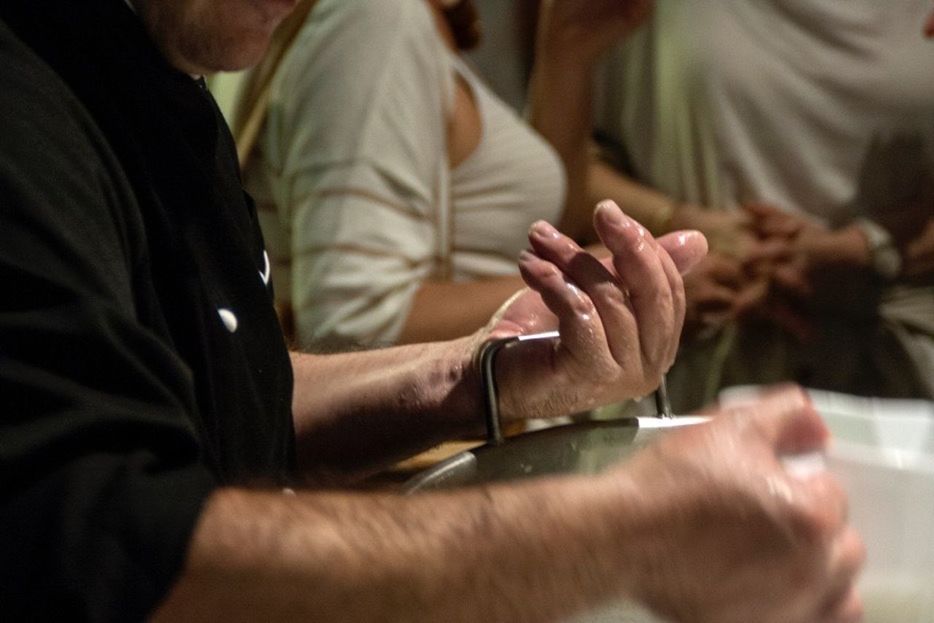 CLOSE-UP OF CROPPED HAND HOLDING WHITE