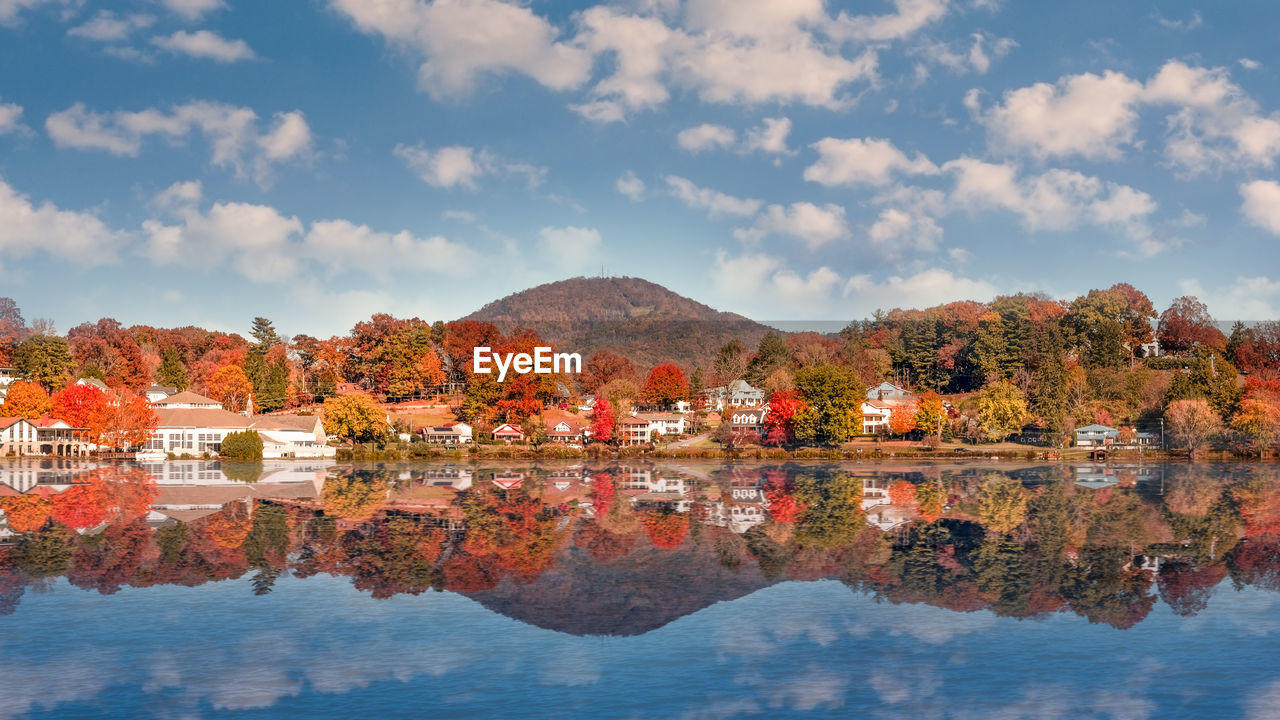 Scenic view of lake by buildings against sky