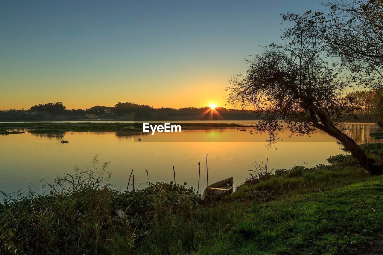 Scenic view of river against sky during sunset
