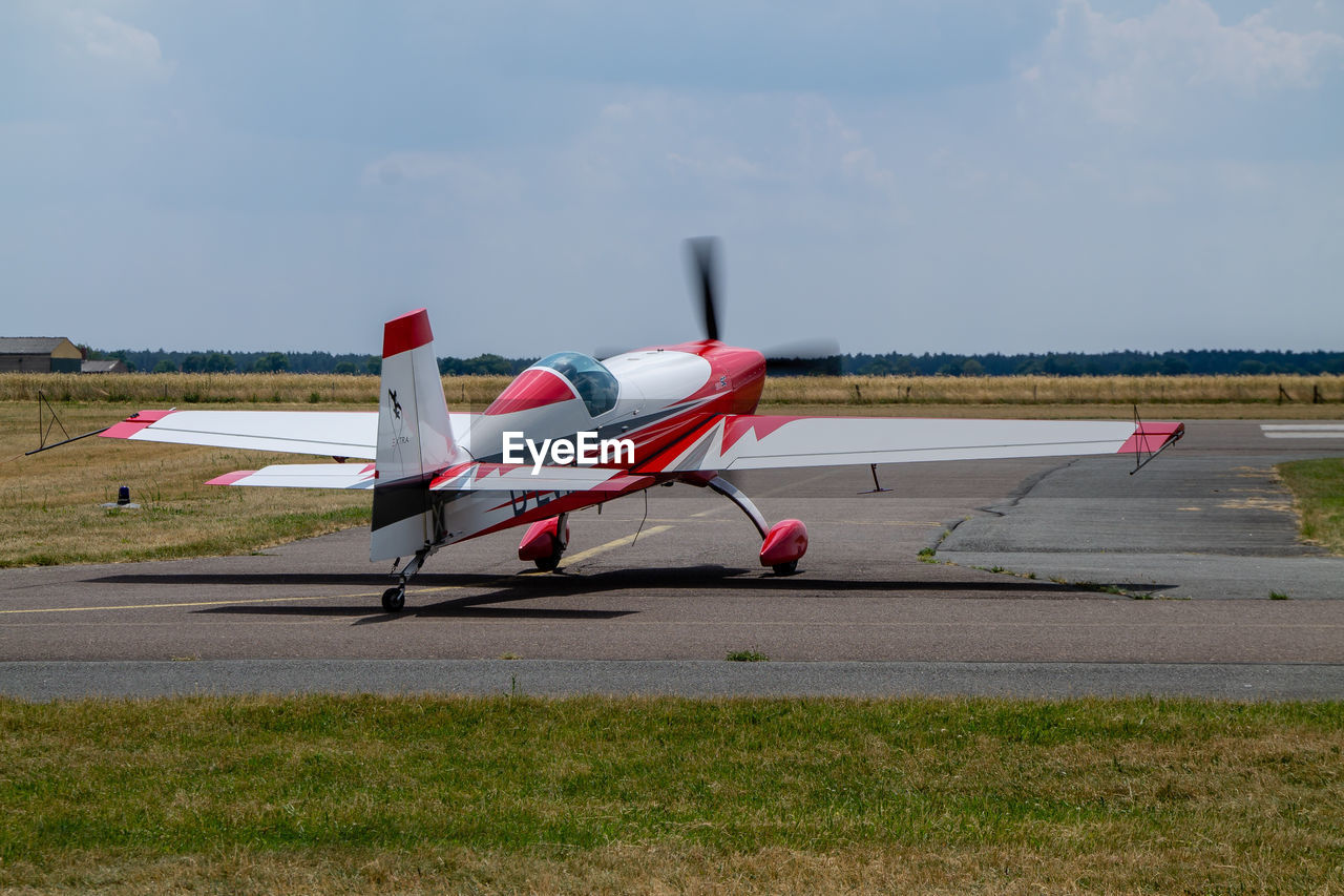 Airplane on airport runway against sky