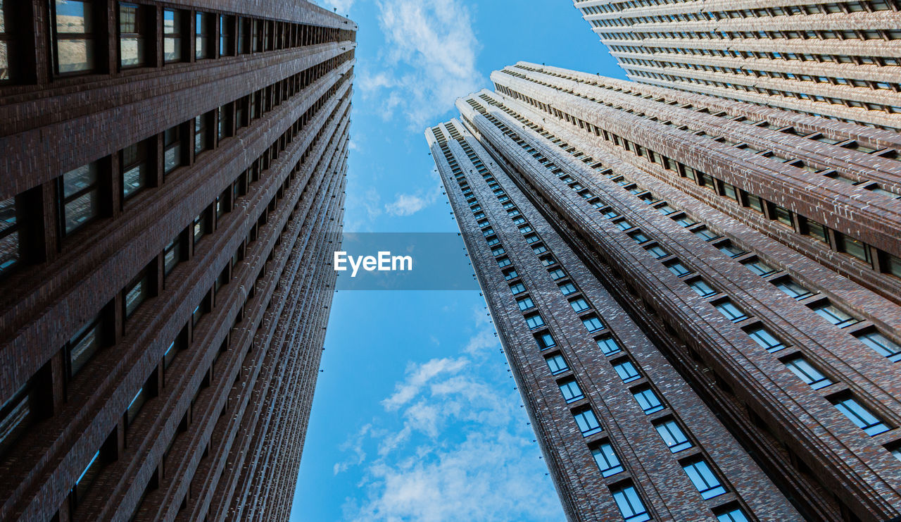 DIRECTLY BELOW SHOT OF MODERN BUILDINGS AGAINST SKY