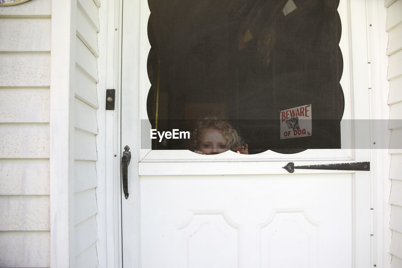 Portrait of girl seen through door