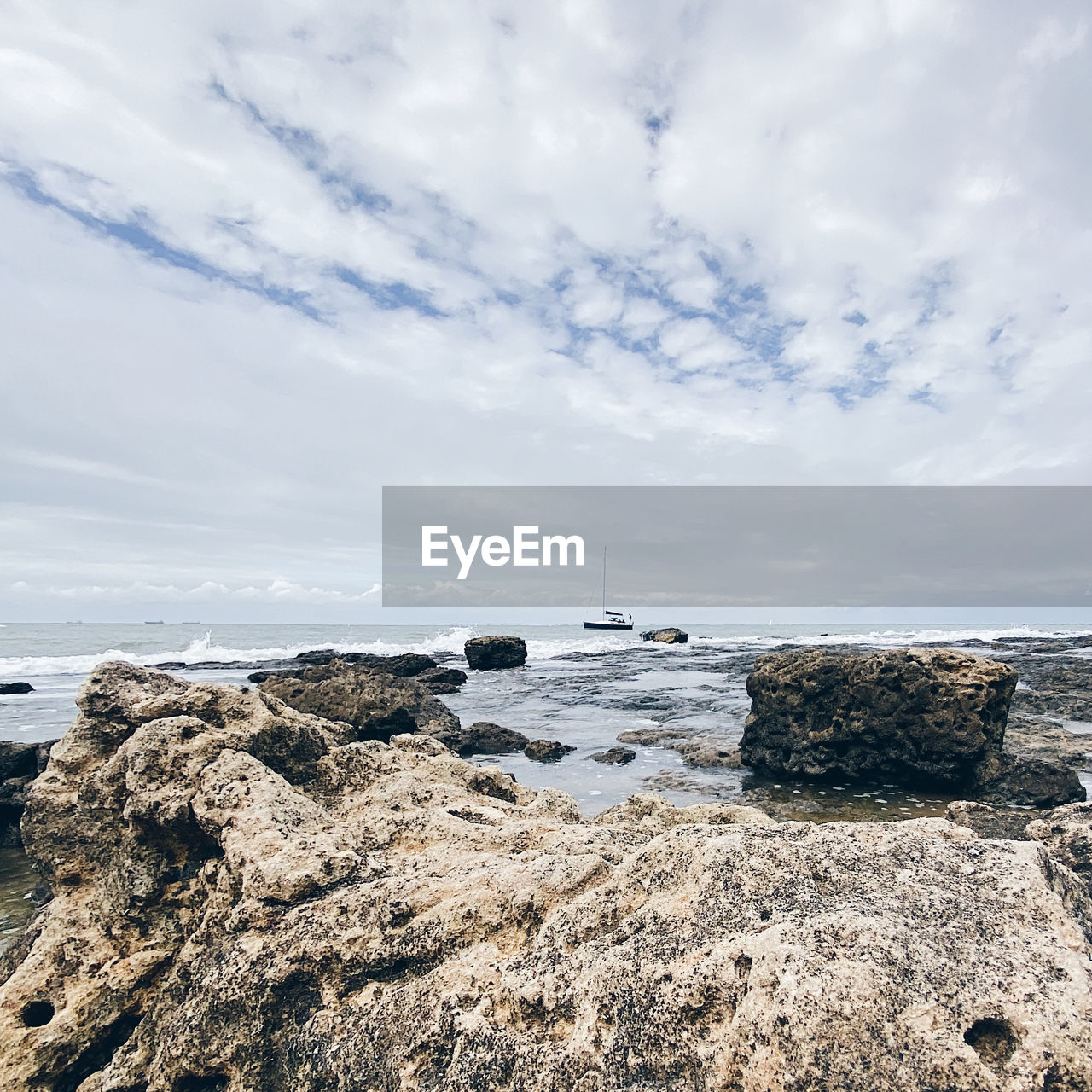 ROCKS ON SHORE AGAINST SKY