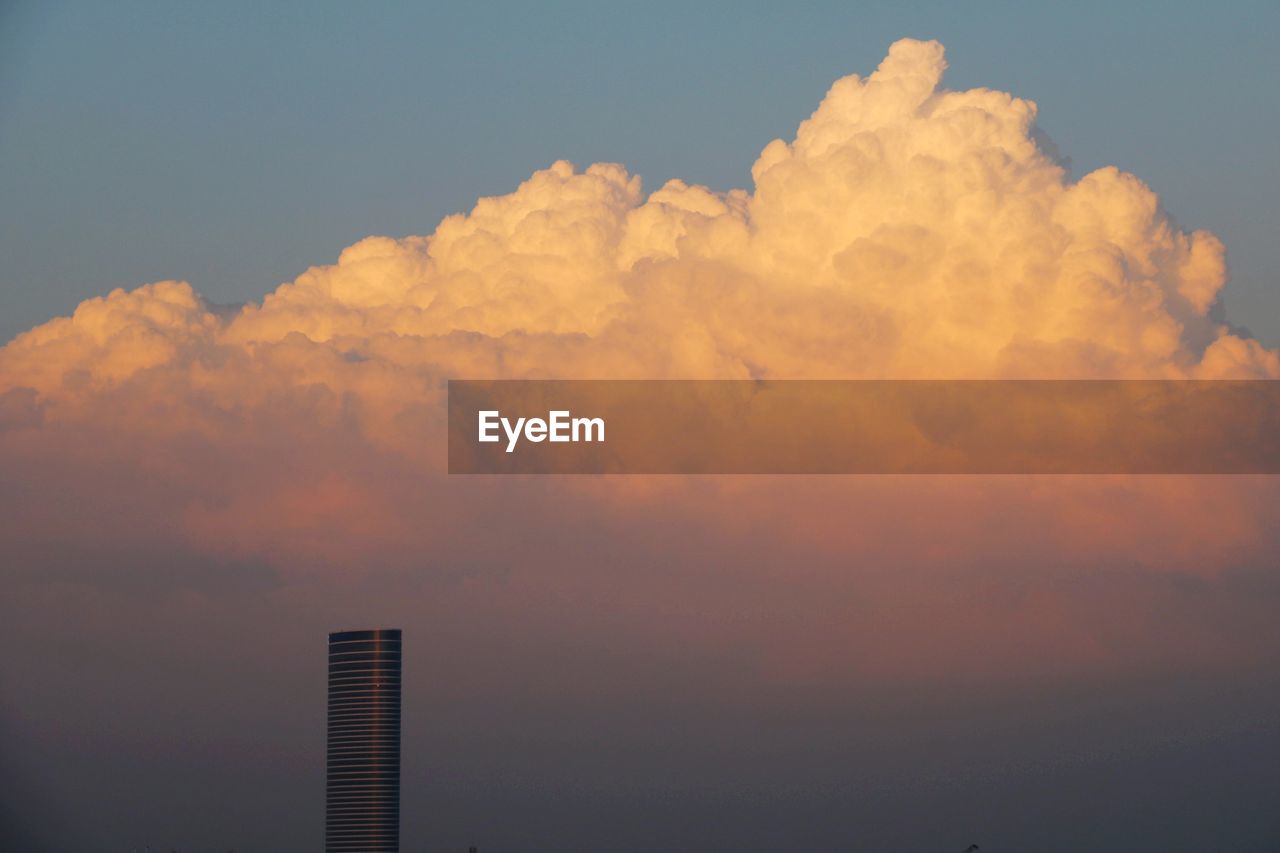 Low angle view of buildings against cloudy sky during sunset