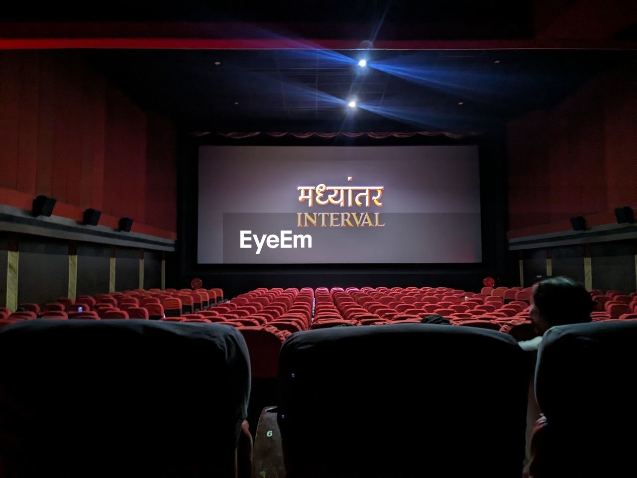 movie theater, auditorium, arts culture and entertainment, seat, theatre, stage, indoors, movie, chair, film industry, stage theater, screen, convention, projection screen, no people, text