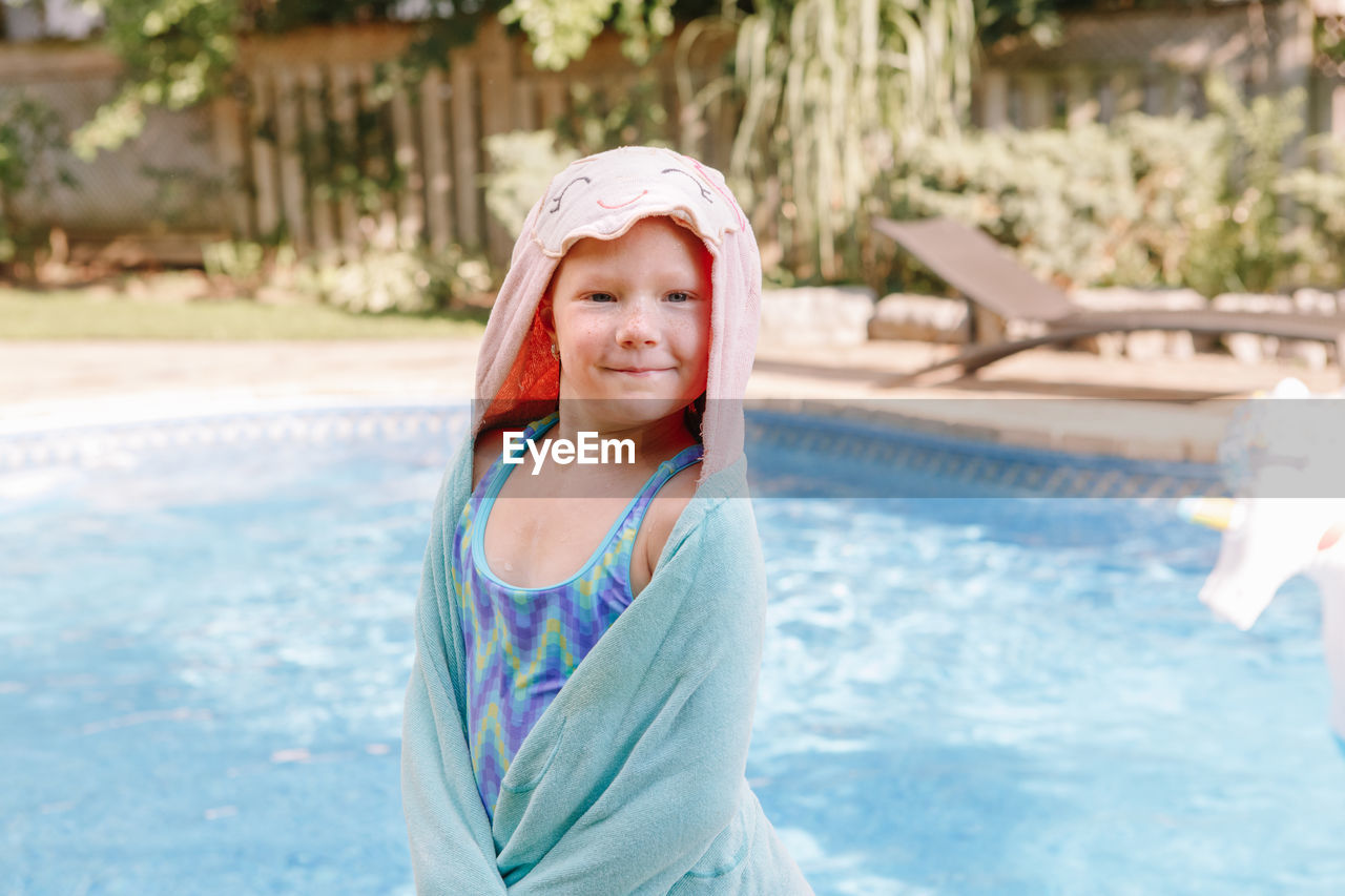 Portrait of smiling girl standing in swimming pool