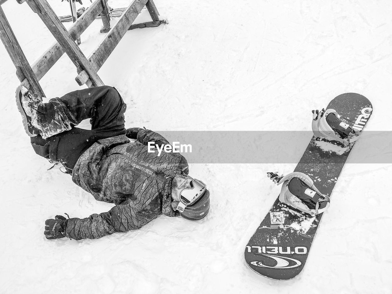 HIGH ANGLE VIEW OF MEN LYING ON SNOW FIELD