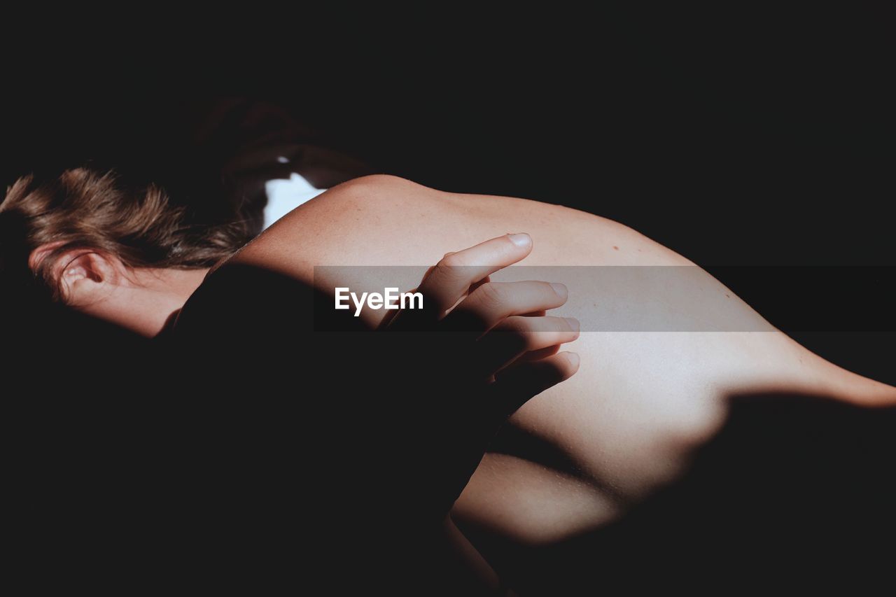 High angle view of topless woman lying on bed