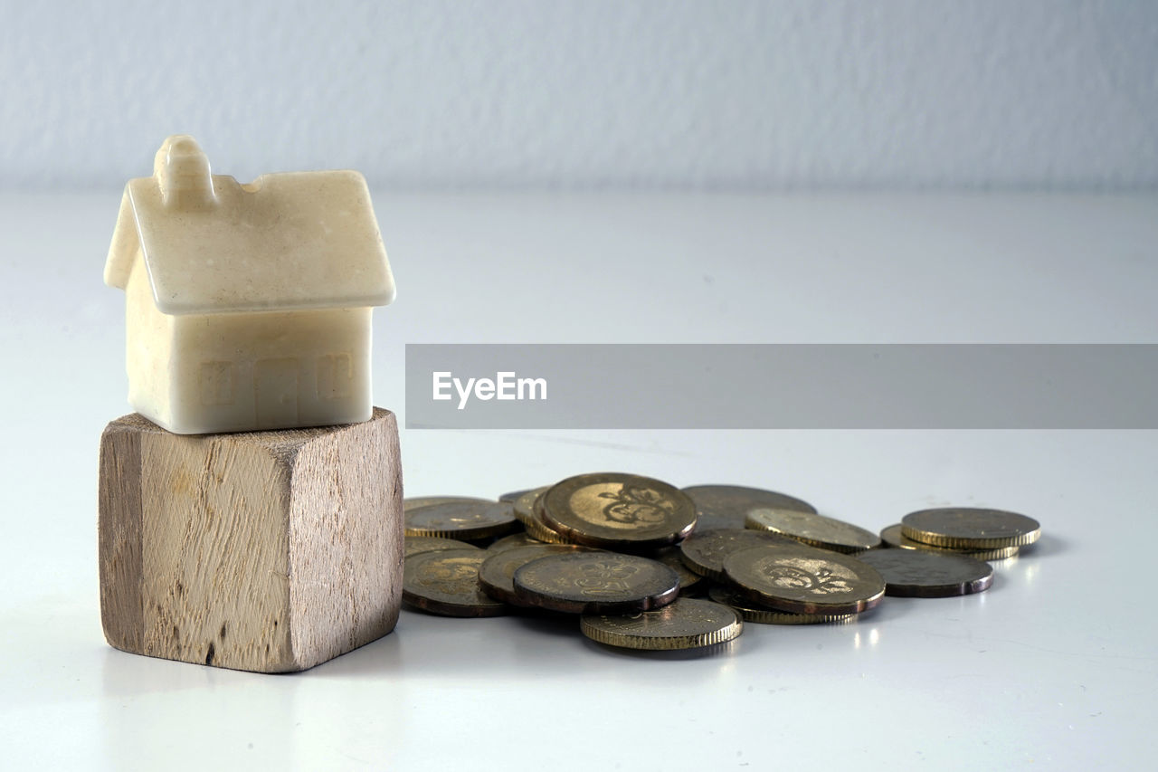 Close-up of coins and model house on table