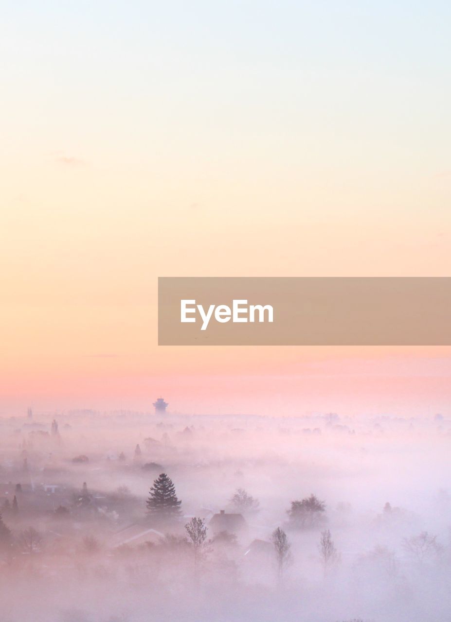 SCENIC VIEW OF FOGGY LANDSCAPE DURING SUNSET