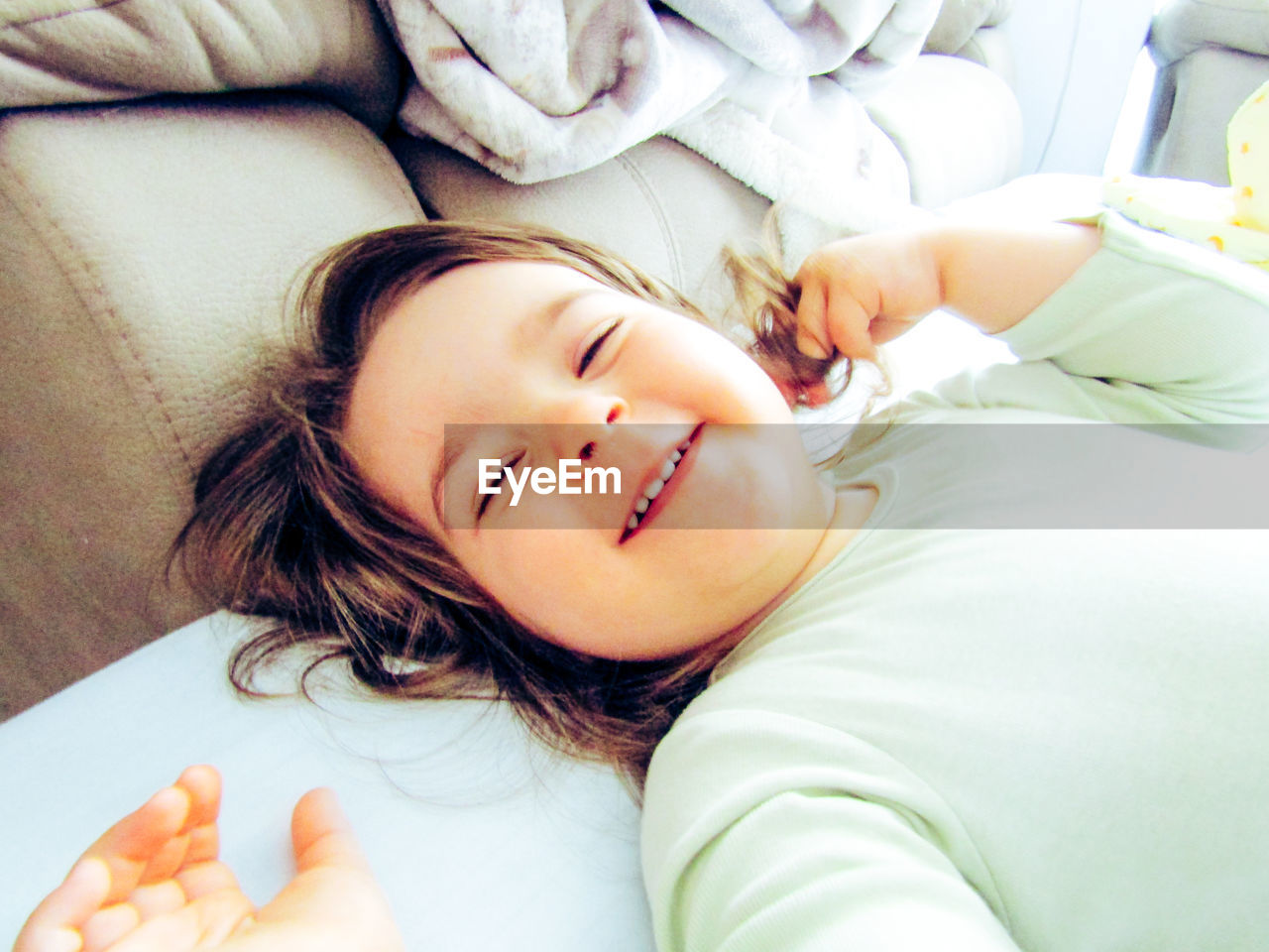 High angle view of smiling girl lying on bed at home