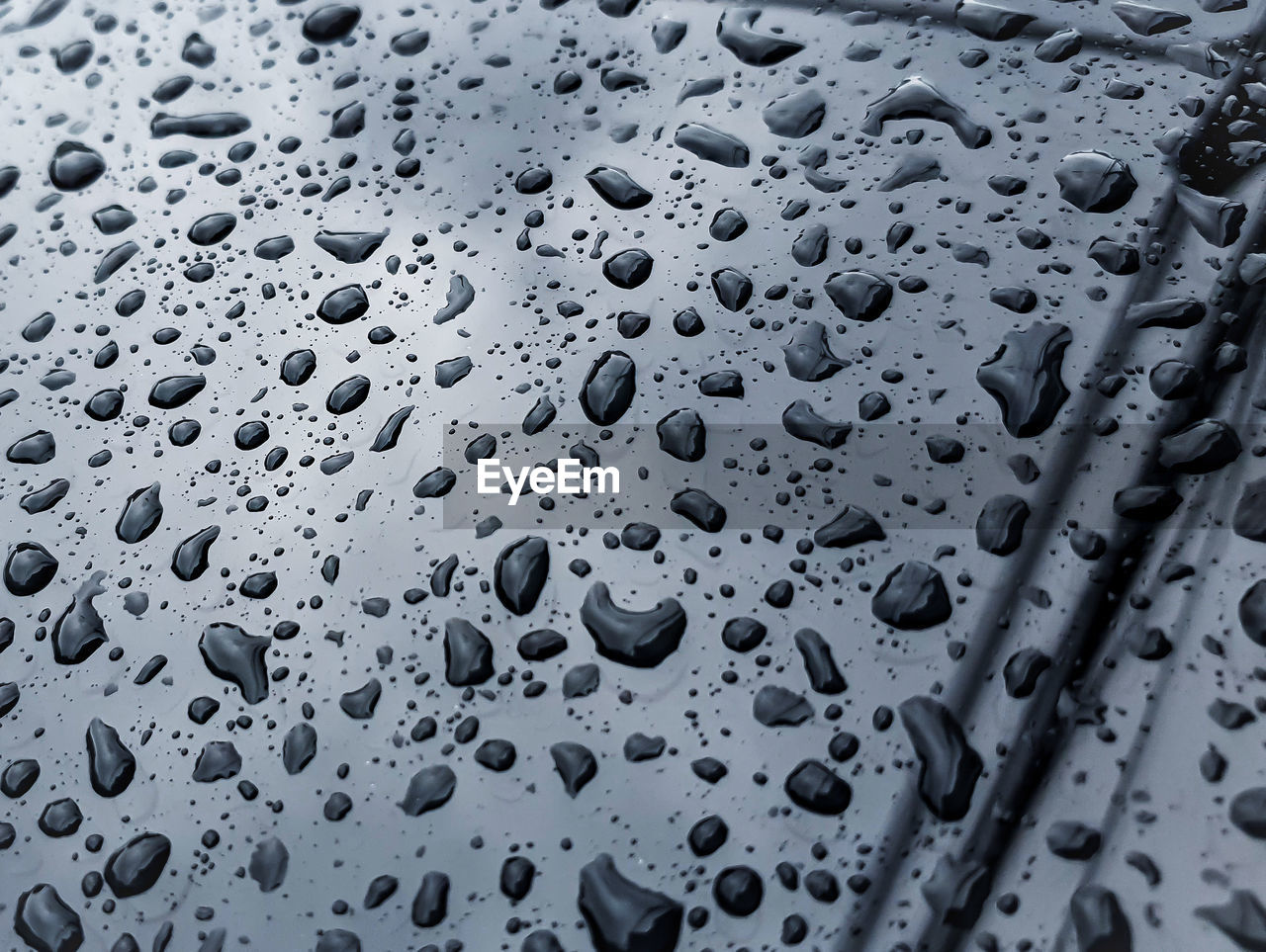 CLOSE-UP OF RAINDROPS ON GLASS WINDOW