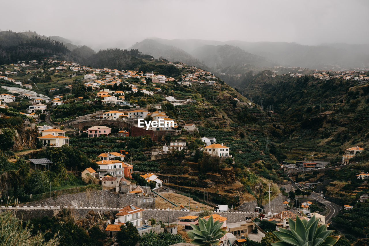 Houses in the green hills and cloudy sky