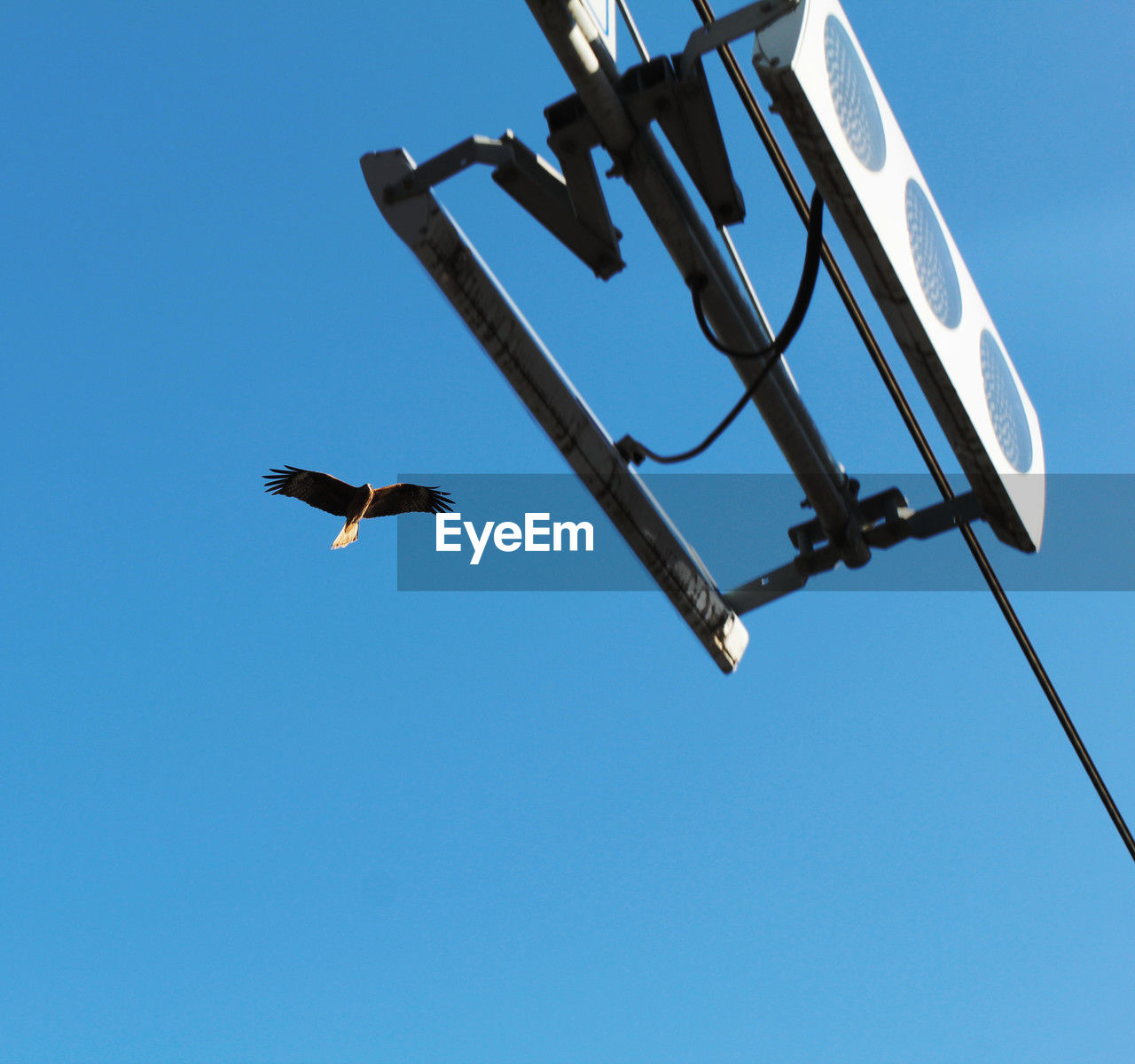 low angle view of security camera against clear blue sky