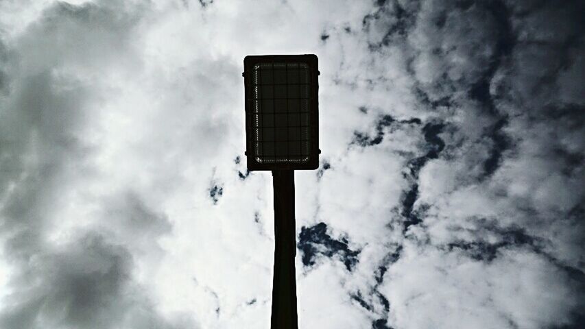 LOW ANGLE VIEW OF STREET LIGHTS AGAINST CLOUDY SKY