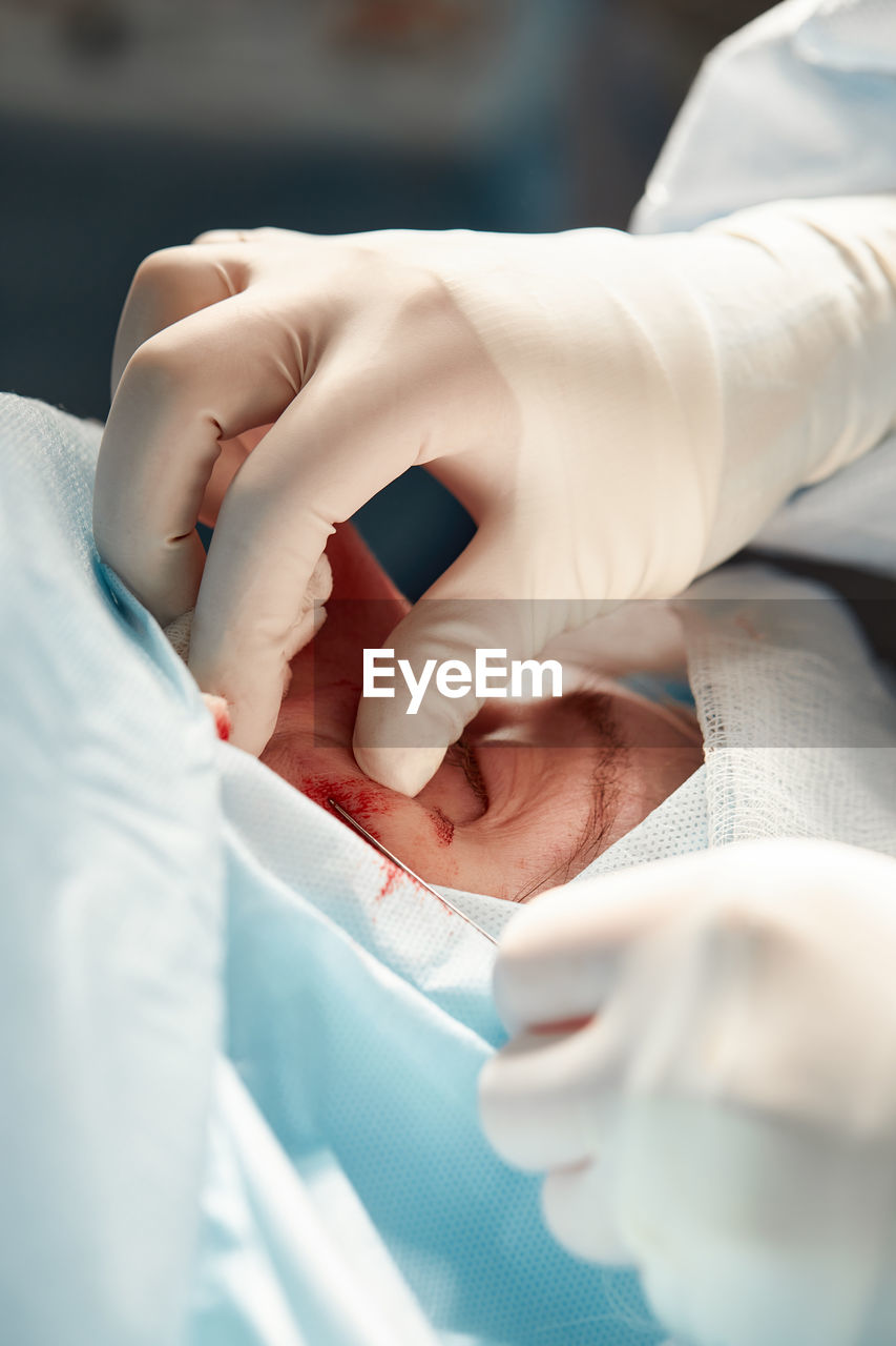 Midsection of doctor performing surgery