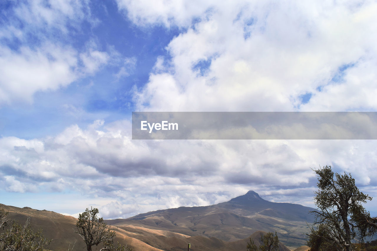 Scenic view of mountains against cloudy sky