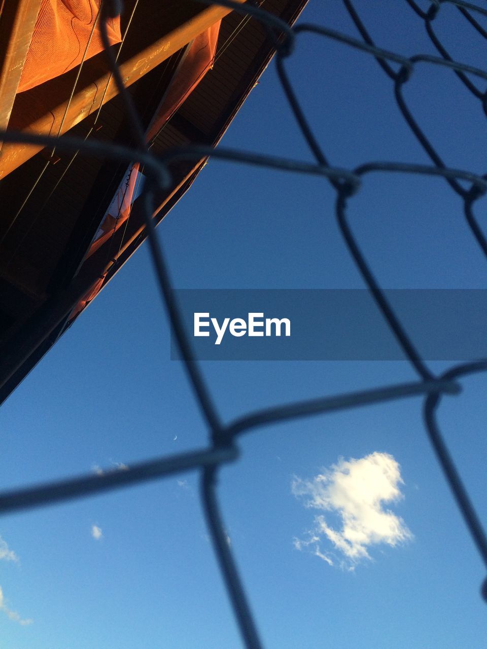 Low angle view of chain link fence against sky