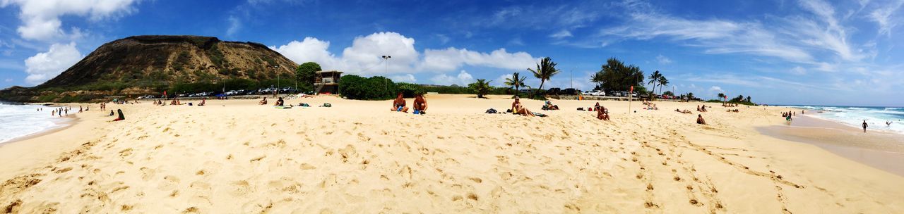 People enjoying at beach against sky