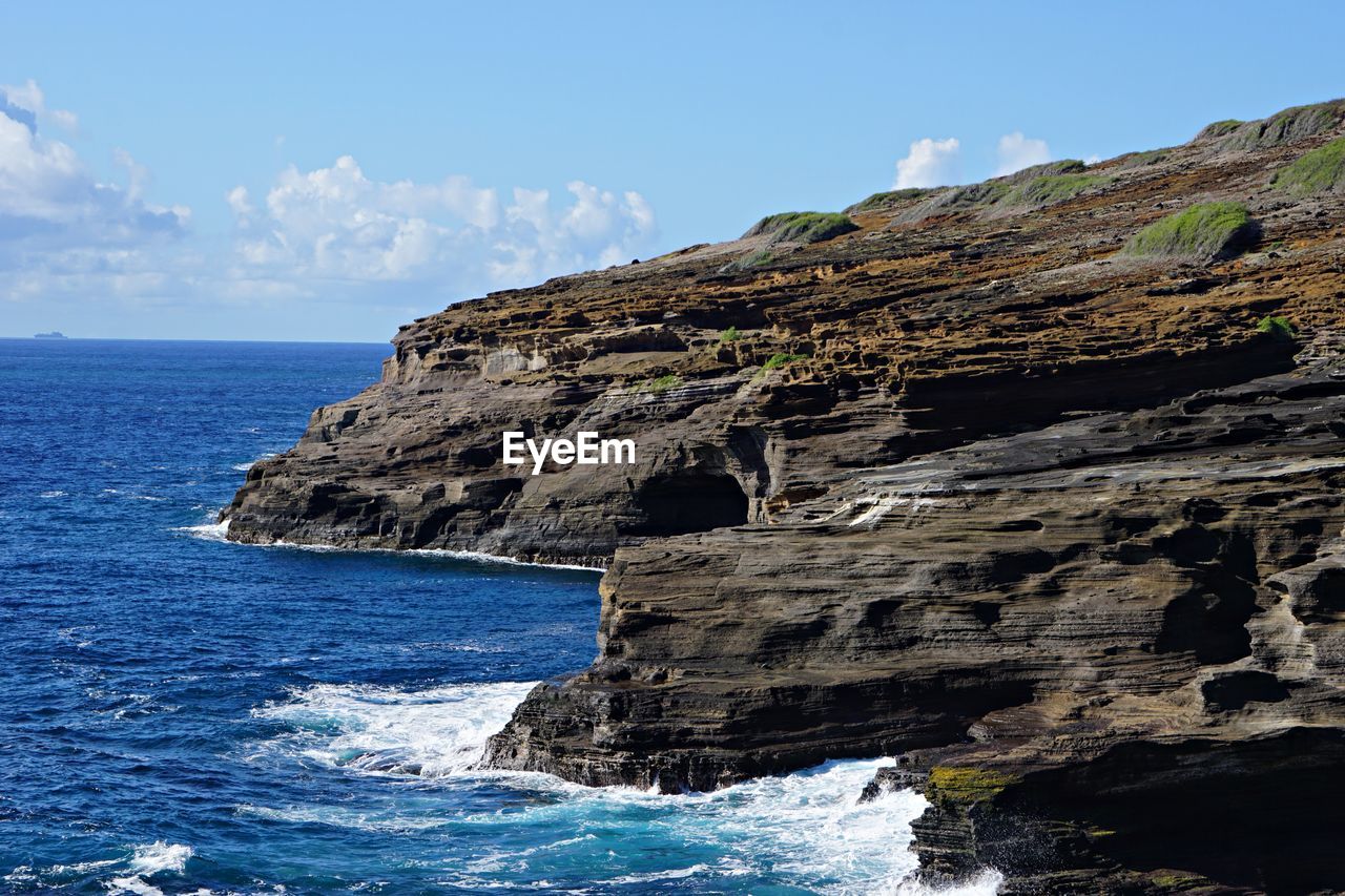 Rock formations by sea against sky