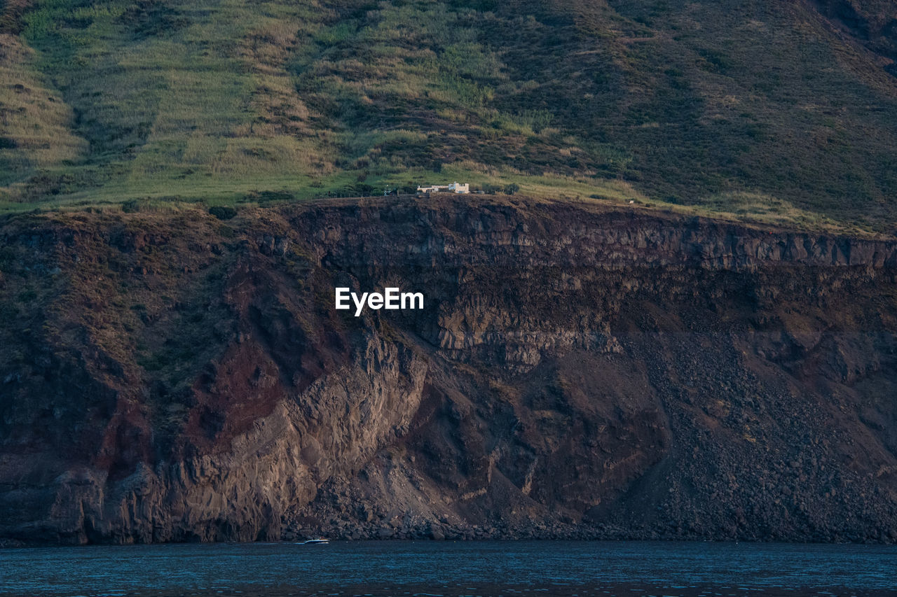 SCENIC VIEW OF SEA BY MOUNTAINS