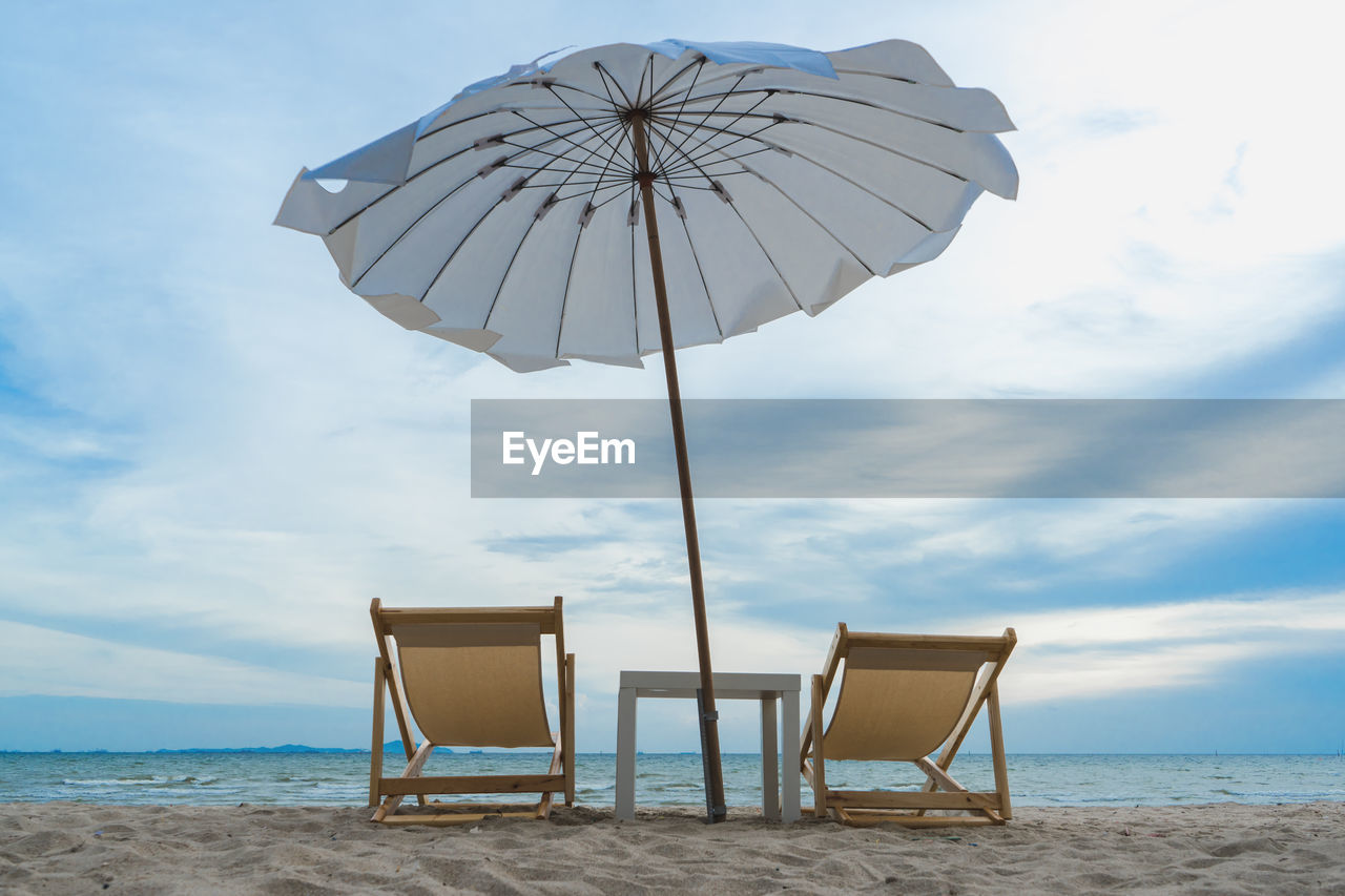 CHAIRS ON BEACH AGAINST SKY