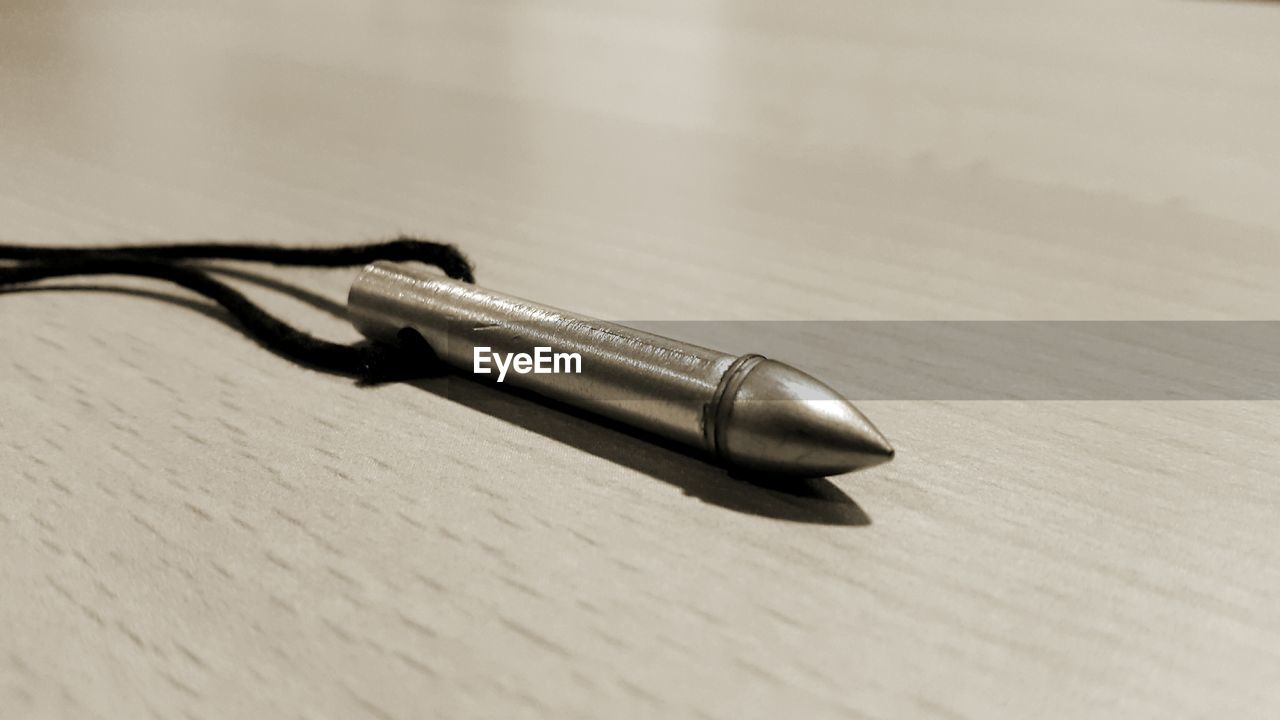 Close-up of metal pendant in necklace on table