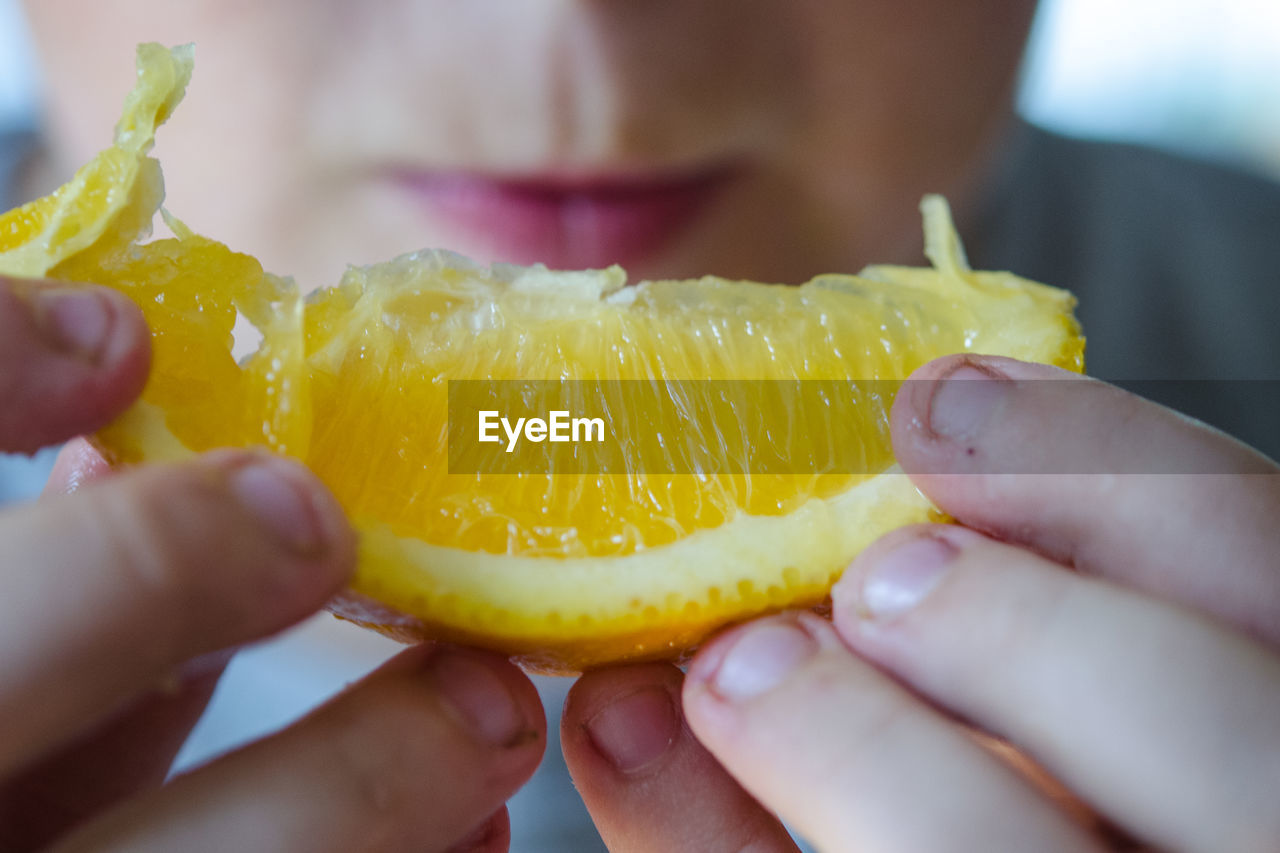 CLOSE-UP OF PERSON HAND HOLDING FRUIT IN BOWL