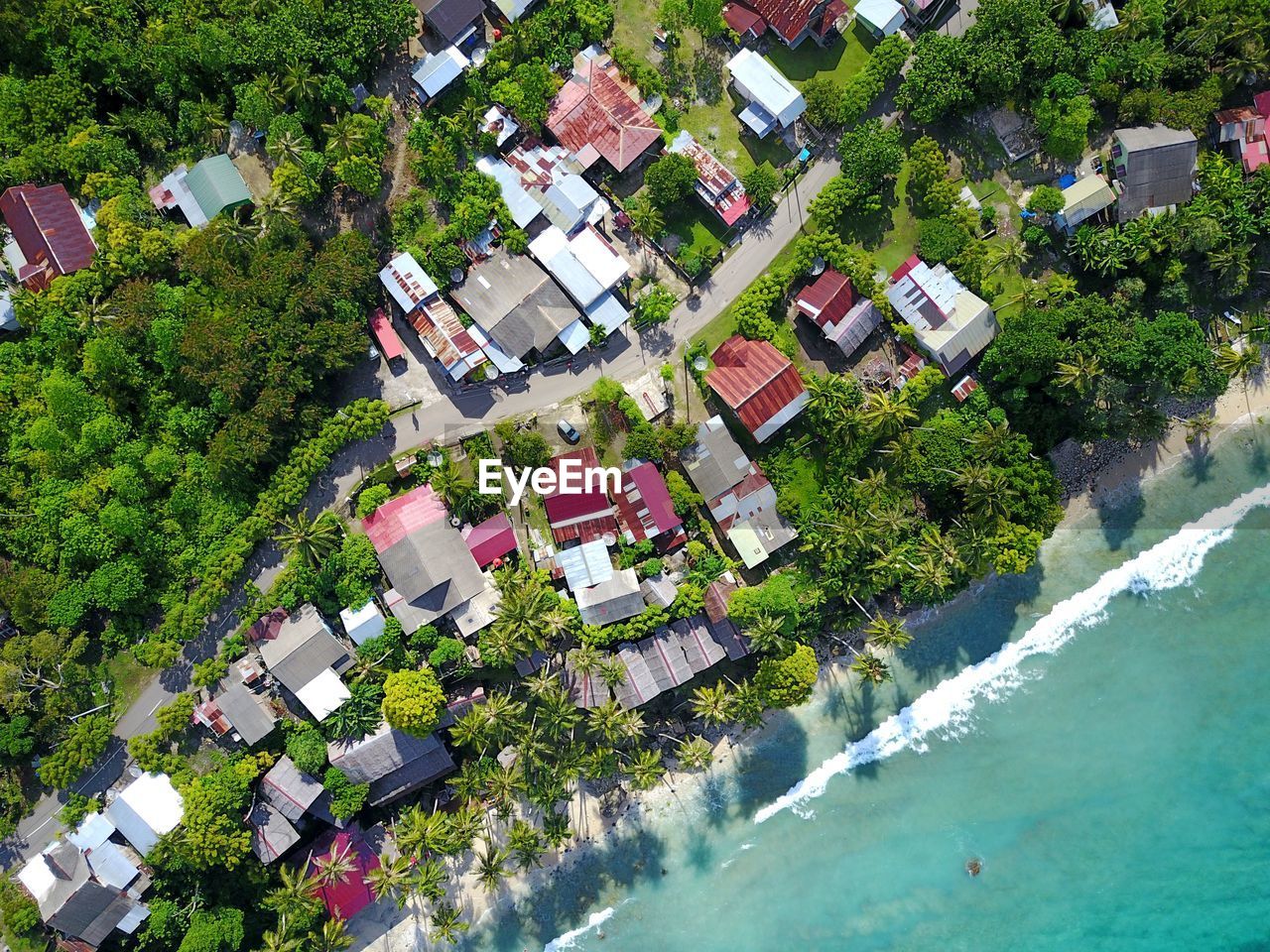 Natural view of coconut trees, beaches and city building from an altitude angle of 100 meters